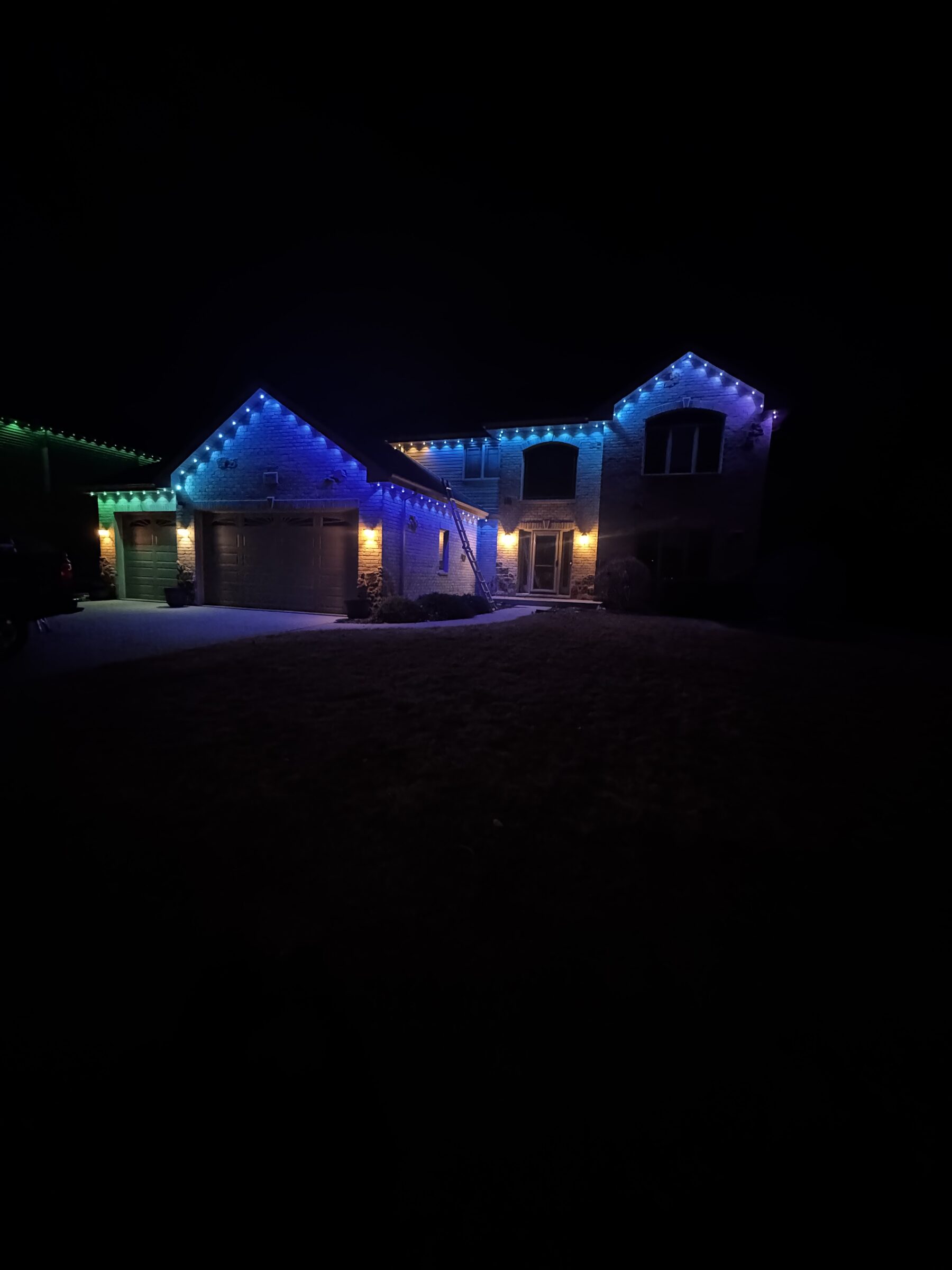 Roof peaks and gables outlined with permanent lighting against a night sky