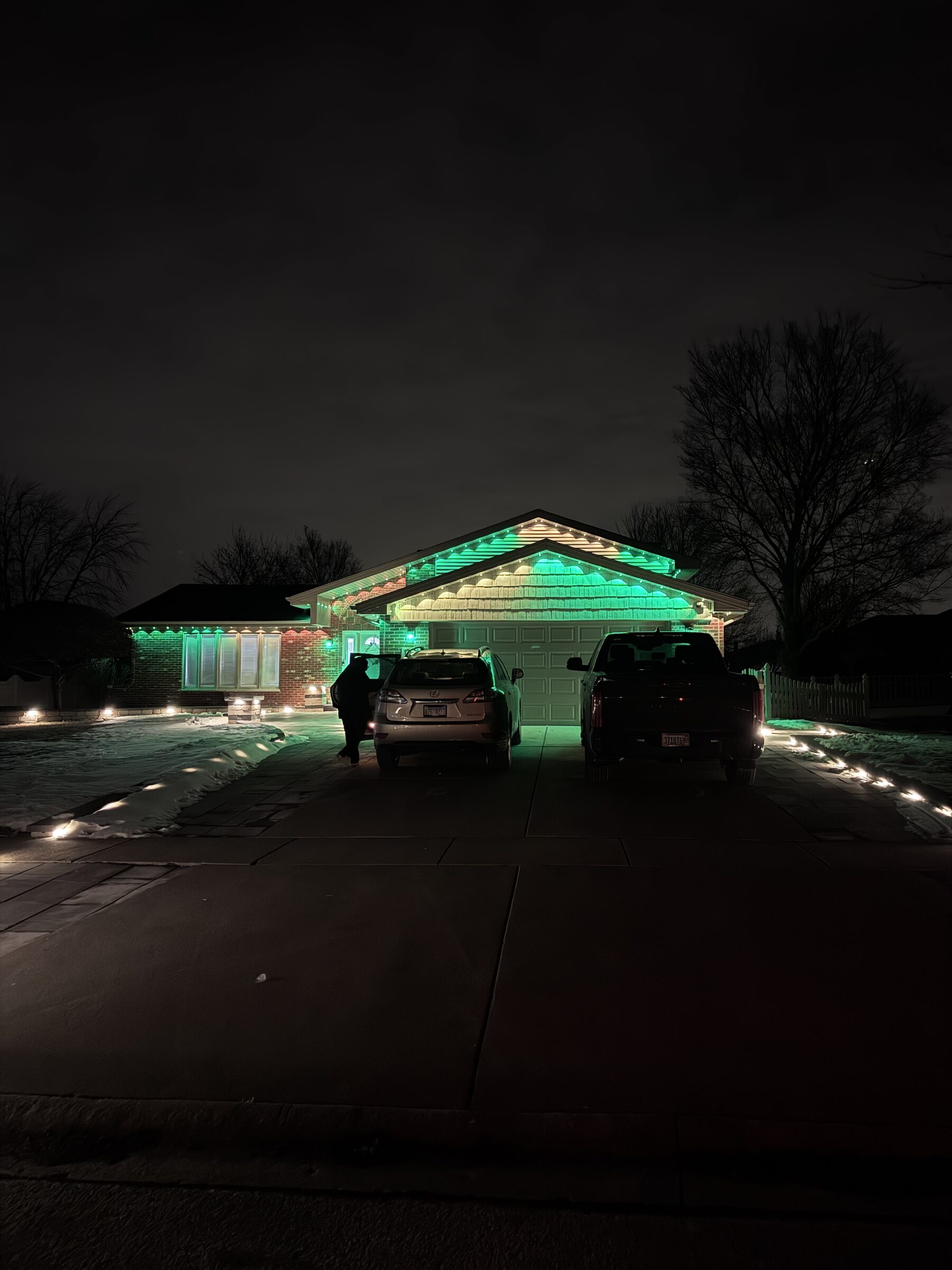 Permanent roofline lighting paired with lighting along the driveway entry